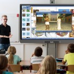 Nauczyciel korzystający z monitora interaktywnego z oprogramowaniem mozaBook.